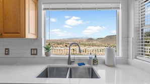 A kitchen with a large window, a sink, and a potted plant. - Best View! 6 Pools & 4 Hot Tubs! Waterslides! Sport Courts! Remodeled! Location! (St. George)