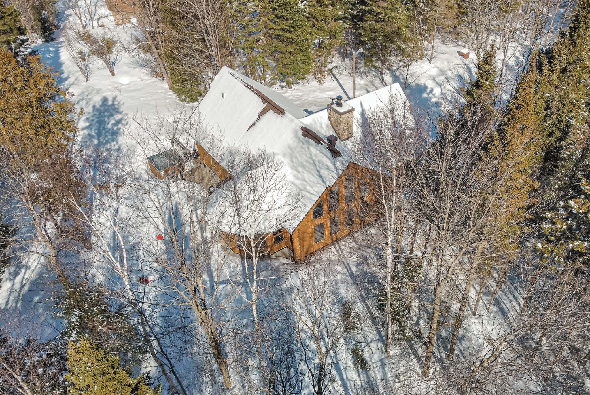 Winter wonderland view of the property with snow-covered rooftops and trees