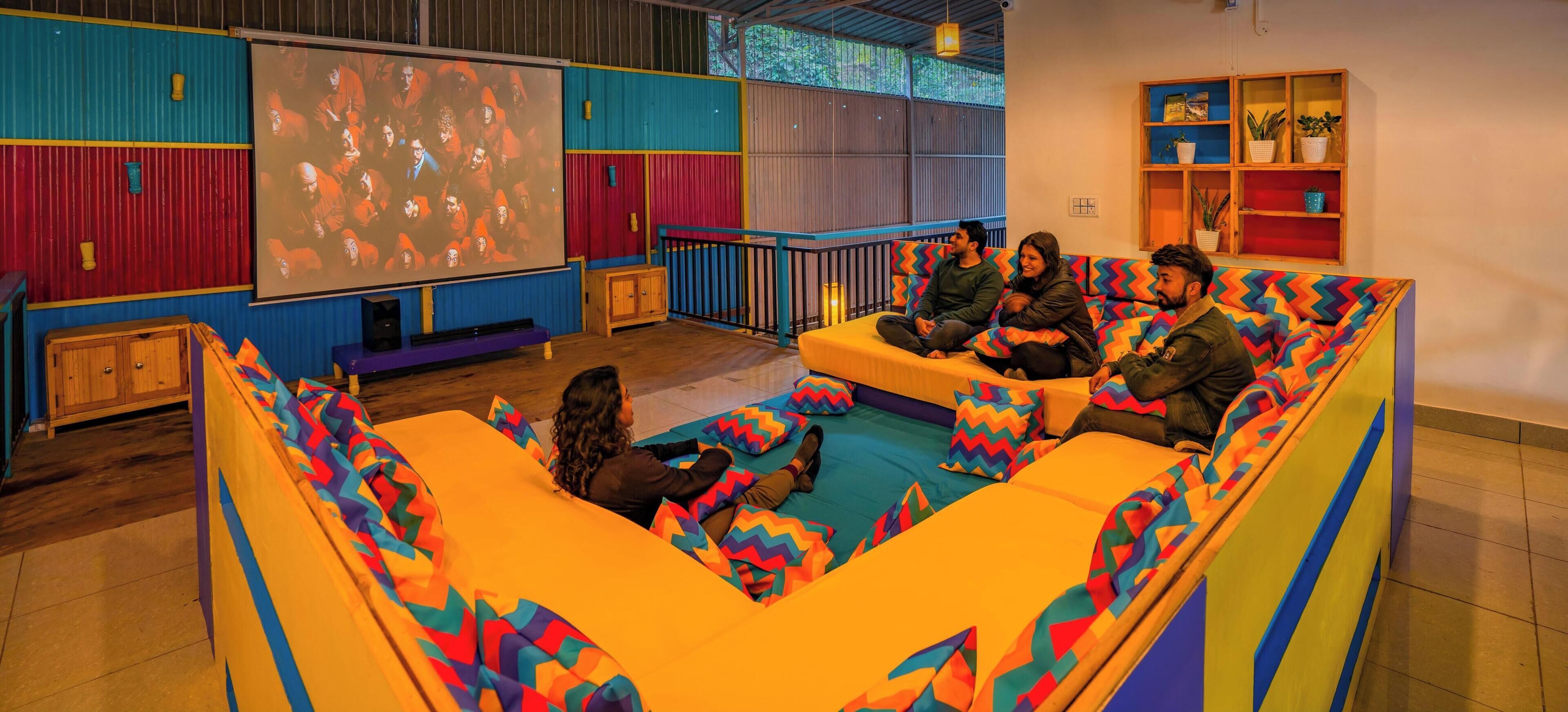 Un teatro con asientos de colores y una pantalla grande.