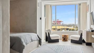 Relax in a spacious room with a large bed, desk, and city view.