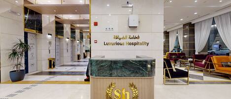 A hotel lobby with a reception desk, a sign reading "Luxurious Hospitality," and a seating area with sofas.