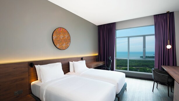 A hotel room with two beds, a desk, and a large window offering a view of the outdoors. - Quest Hotel Midport Port Dickson (Port Dickson)