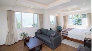 A modern hotel room with a sofa, a bed, a desk, and a chair. - Bhutan Peaceful Residency and Spa (Thimphu)