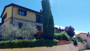 Stunning two-story residence with a charming facade, dormer windows, and lush greenery.