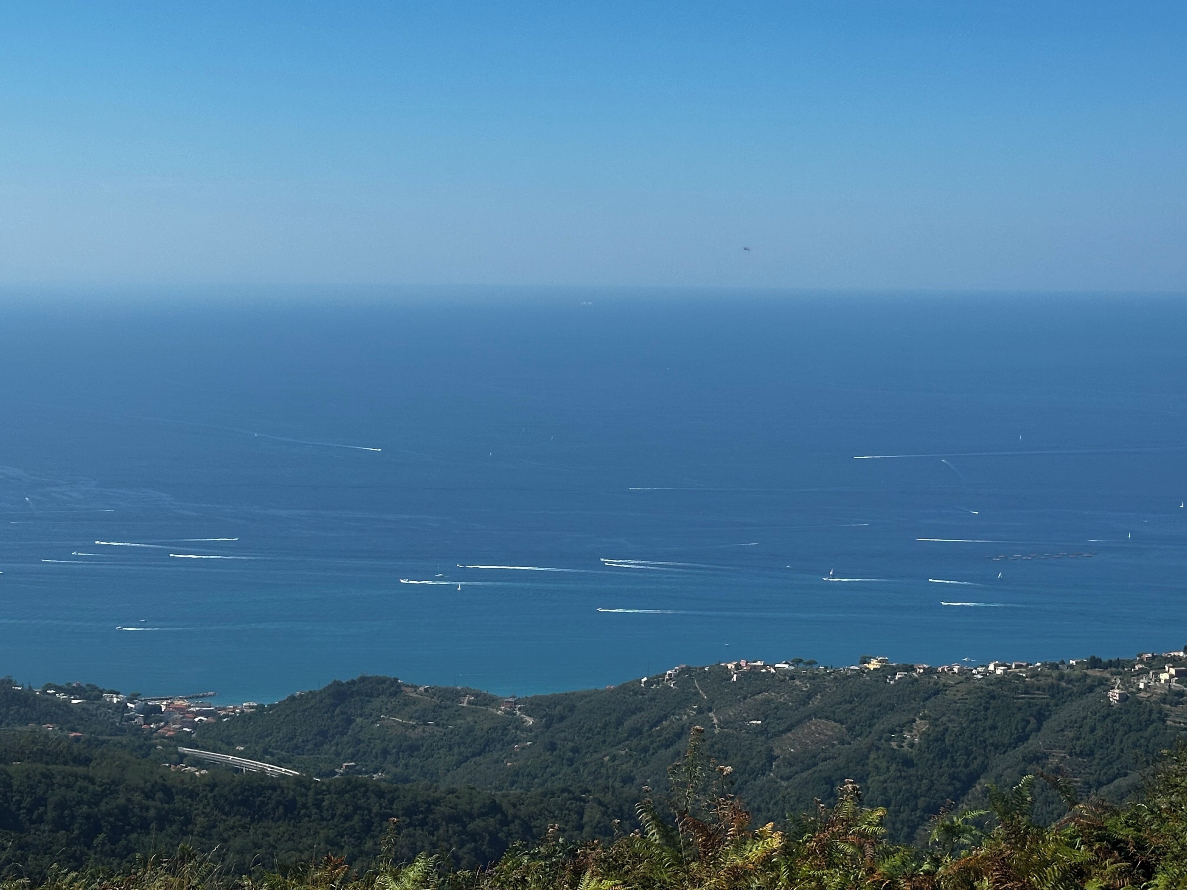 Eine Küstenlandschaft mit freiem Blick auf das Meer und hügeligem Gelände im Vordergrund.