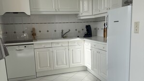 A kitchen with white cabinets, a dishwasher, and a refrigerator. - Vacation home 300 m from the sea St Denis D'oleron (Saint-Denis-d'Oléron)
