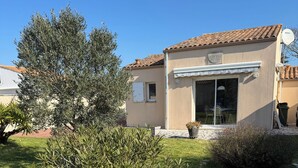 A house with a tiled roof, a covered patio, and a lawn. - Vacation home 300 m from the sea St Denis D'oleron (Saint-Denis-d'Oléron)