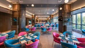 A spacious restaurant with multiple tables and chairs, featuring a modern interior design and large windows. - Pagoda Hotel Shanghai Baixia near Jingan Temple (Shanghai)