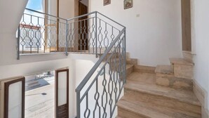Una escalera con barandilla de metal que sube a un segundo piso.