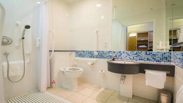 A modern bathroom with a shower, toilet, and sink.