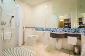 A modern bathroom with a shower, toilet, and sink.