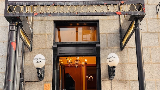 Entrada de hotel con un cartel que dice 'OYO' y 'Highland Gate'.