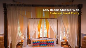 A four-poster bed with a canopy, a bedside table with a lamp, and a window with curtains. - goSTOPS Ooty (Ooty)