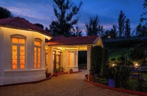 A house with a red-tiled roof, a covered porch, and a brick pathway leading to the entrance. - goSTOPS Ooty (Ooty)