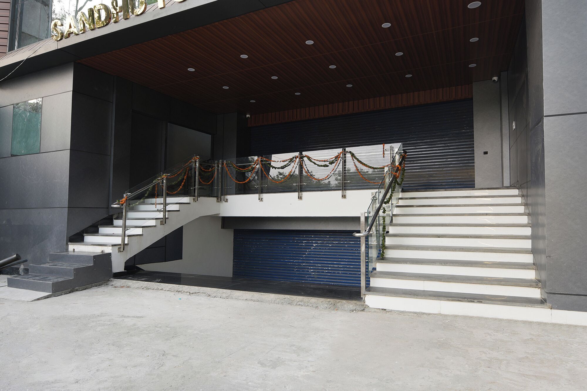 A modern building with a staircase leading to a second floor, decorated with garlands.