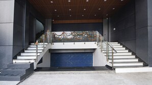 A modern building with a staircase leading to a garage door. - Fabhotel Evergreen (Faridabad)