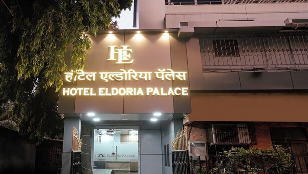 Hotell Eldoria Palaces entré, med en modern fasad och upplyst skyltning.