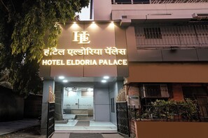 Hotel Eldoria Palace's indgang med en moderne facade og oplyst skiltning.