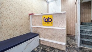En receptionsdisk med en skylt med texten ”fantastiska hotell”, väggar klädda i marmor och en trappa.