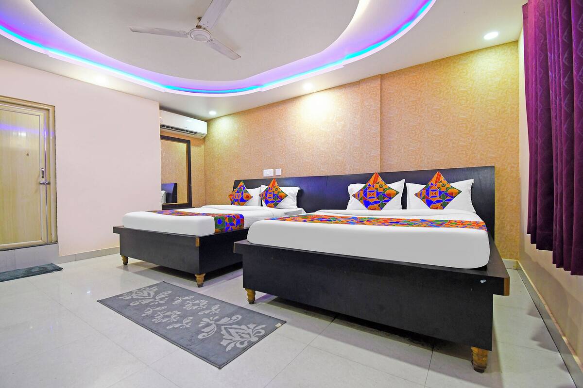 A hotel room with two beds, a ceiling fan, and a modern design.