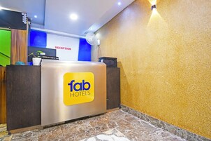 Un mostrador de recepción de hotel con un cartel de 'fab hotels', una zona de recepción y un mostrador de salida.