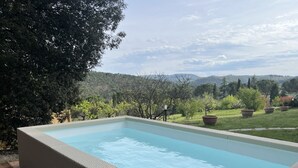 A rectangular swimming pool with a tiled edge, surrounded by a wooden deck. - Casa Riccimballa (Impruneta)
