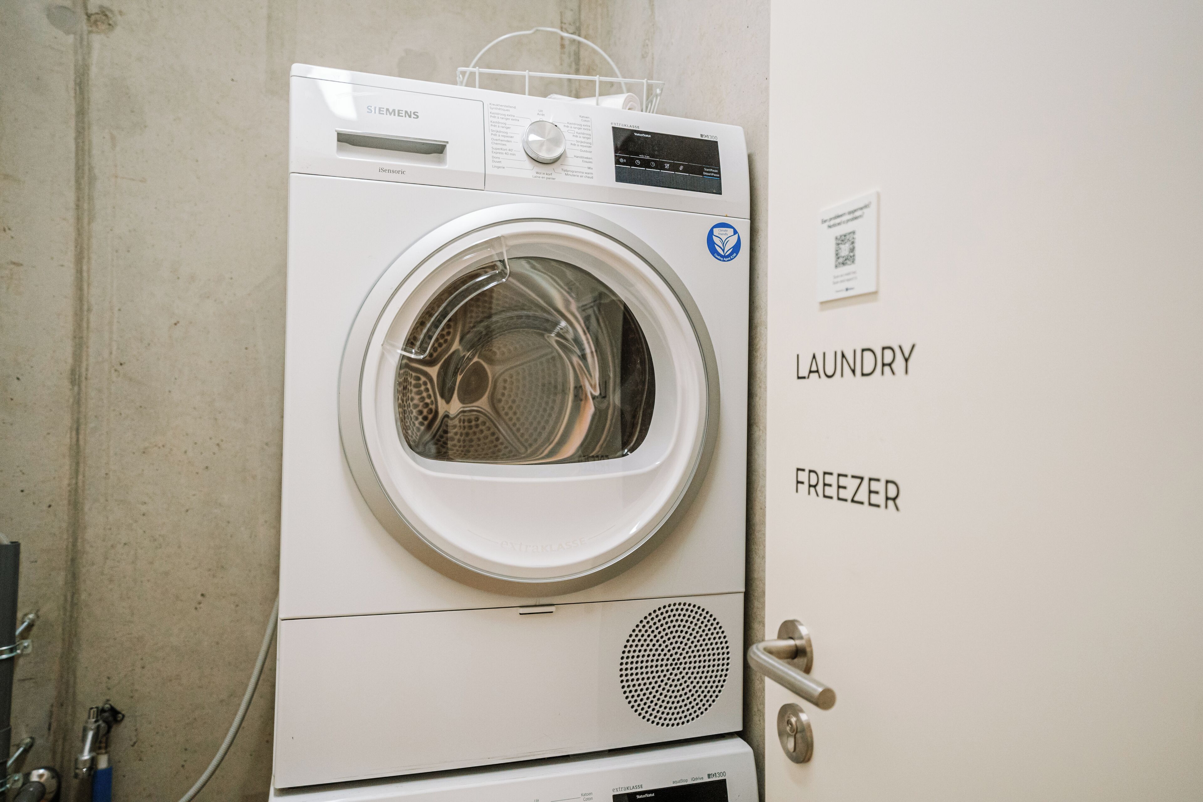 A white laundry and freezer unit with a control panel and a QR code.