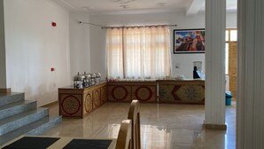 Un espacio habitable amplio con una encimera de cocina, una escalera y un gran ventanal con cortinas.