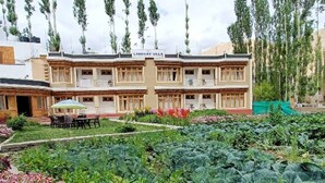 Un edificio de dos plantas llamado 'Lonchay Villa' con un jardín delantero.