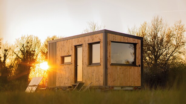 A wooden cabin with a door and windows, surrounded by tall grass and trees. - L'Échappée Royale - Tiny House 20 minutes from Beauval Zoo (Billy)