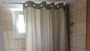 Een badkamer met toilet, wastafel en douchegordijn.