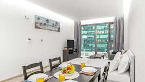 Een moderne hotelkamer met een zithoek, een bank en een groot raam met uitzicht op de stad.