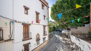 Eine enge Straße mit Häusern, Außenbereich und bunten Wimpeln.