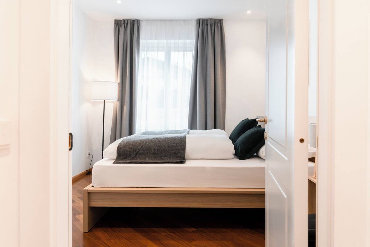 Une chambre à coucher moderne avec un lit, une table de chevet et une lampe.
