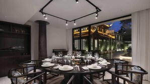 A round dining table set for a meal with chairs around it, a large window with a view of a building, and a modern ceiling light fixture. - Chengdu Qingyang Palatio Huajian Mansion (Chengdu)