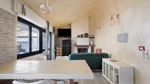 A compact kitchen with a dining area, a built-in refrigerator, and a fireplace.