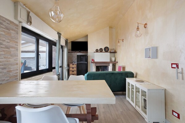 A compact kitchen with a dining area, a built-in refrigerator, and a fireplace.