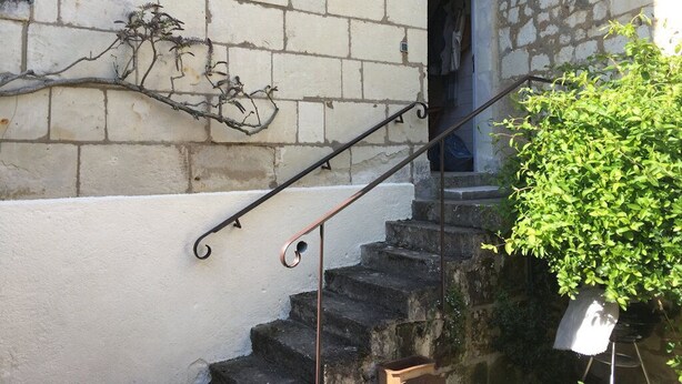 A stone staircase with a metal handrail leading to a door. - Charming gîte in the Loire castles (Candes-Saint-Martin)
