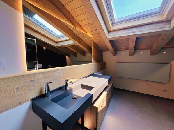 A modern bathroom with skylights, a large mirror, and a wooden ceiling. - 45 m² Room with Private Bathroom – Up to 2 Guests (Illasi)