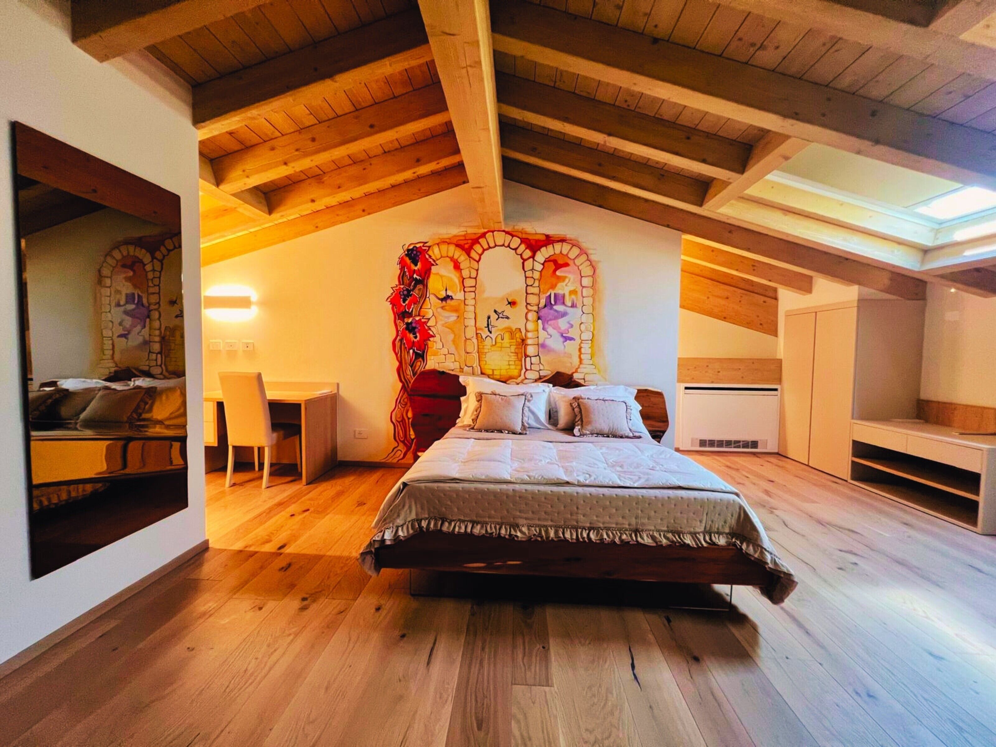 Une chambre avec un plafond en bois, un lit avec des oreillers, un bureau et une chaise.