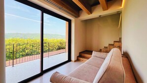 A modern interior with a large window, a staircase, and a sofa. - 45 m² Soundproof Room with Private Bathroom and Terrace – Up to 4 Guests (Illasi)