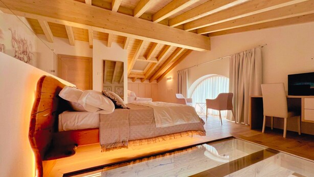 A modern bedroom with a glass floor, wooden beams, a bed, a desk, and a chair. - 45 m² Soundproof Room with Private Bathroom and Terrace – Up to 4 Guests (Illasi)