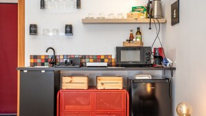 A compact kitchen with a microwave, coffee machine, and storage cabinets. - Studio 'Il Tuo Rifugio' with Balcony, Wi-Fi and Air Conditioning (Modica)