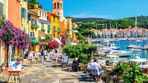 A coastal town with colorful buildings, a bell tower, and a marina with boats. - Apartment 'Proche Mer' with Shared Pool, Wi-Fi and Air Conditioning (Argelès-sur-Mer)
