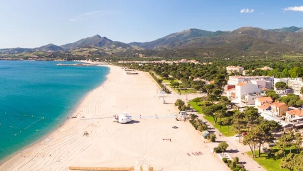 A coastal town with a beach, buildings, and mountains in the background. - Apartment 'Proche Mer' with Shared Pool, Wi-Fi and Air Conditioning (Argelès-sur-Mer)