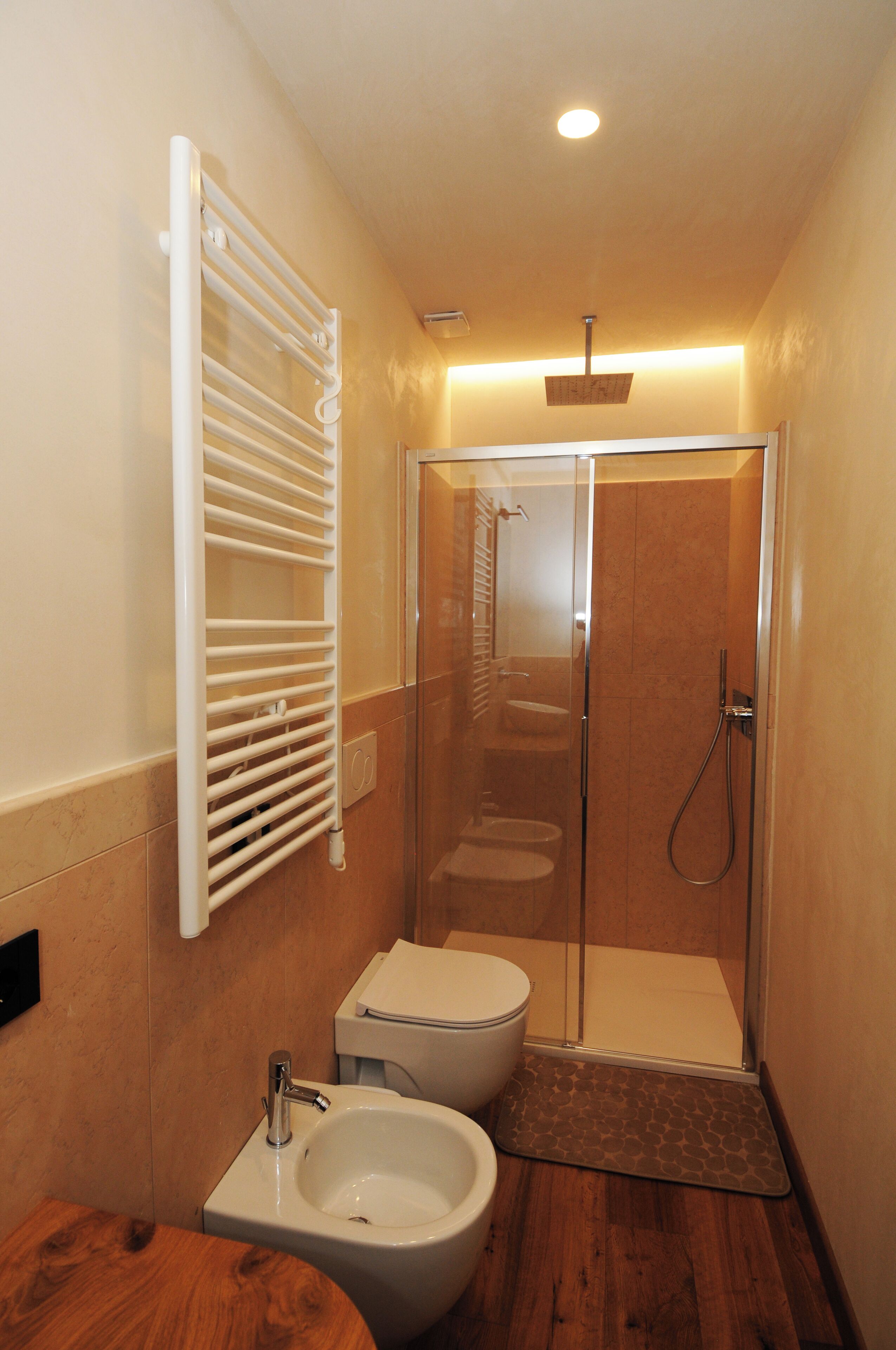 Un bagno con doccia vetrata, un WC bianco e un bidet.