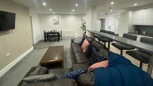 A modern living room with a sofa, coffee table, and dining area. - Apartment 07 St Andrews (Lytham St. Anne's)
