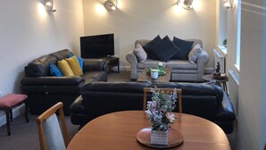 A living room with a sofa, a television, and a coffee table. - 04 St Andrews - Sleeps 6 (Lytham St. Anne's)