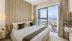 Une chambre d’hôtel moderne, dotée d’un grand lit, offrant une vue sur la ville et permettant d’admirer le paysage urbain à travers la fenêtre.