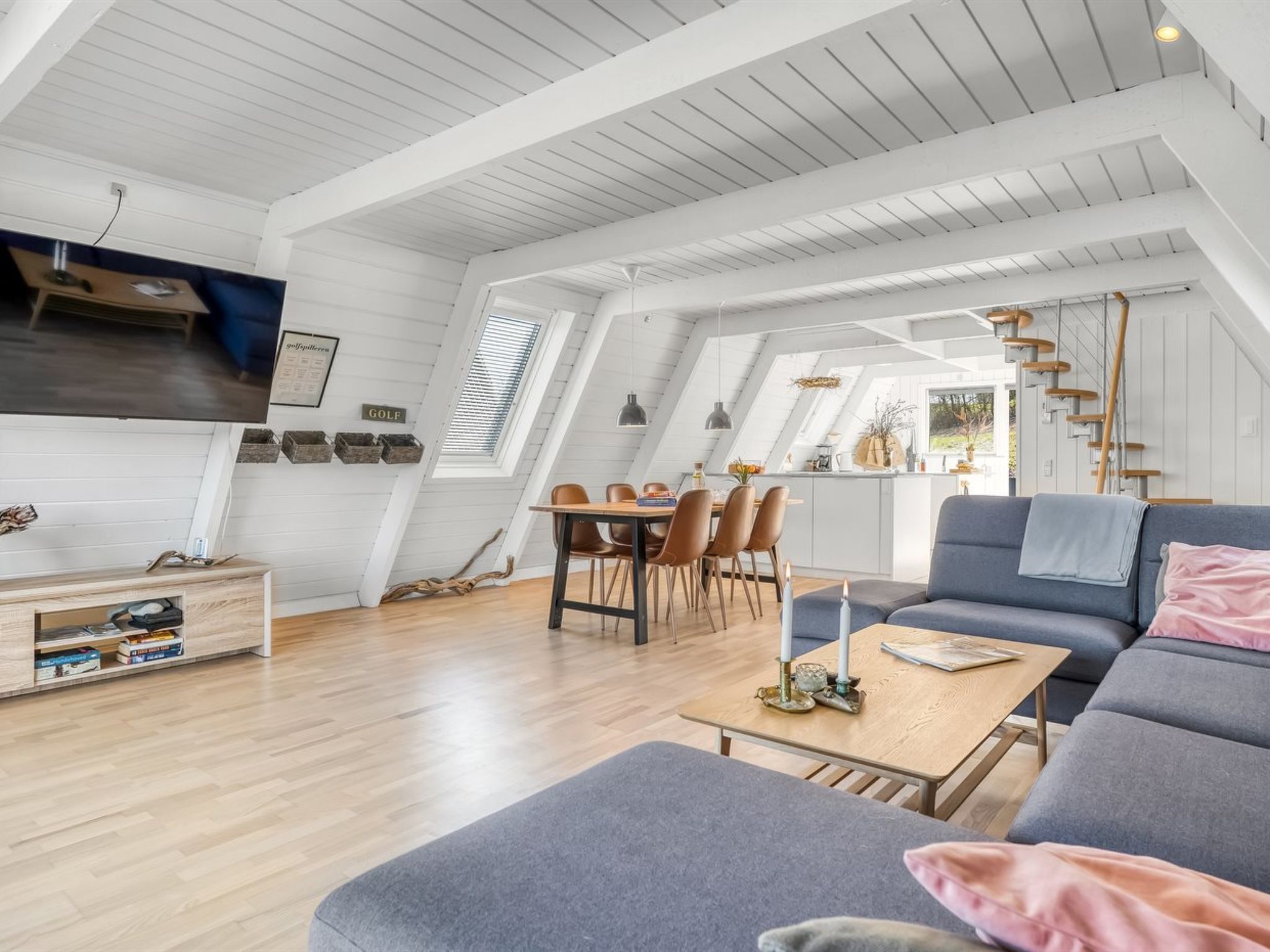 Un loft spacieux comprenant un coin repas, un canapé et un escalier.